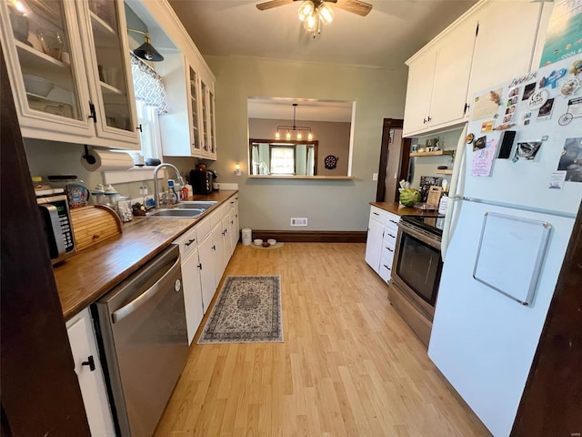 kitchen featuring white cabinets, appliances with stainless steel finishes, pendant lighting, and sink