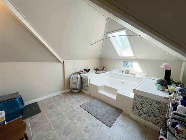 bathroom featuring vaulted ceiling with skylight and a washtub