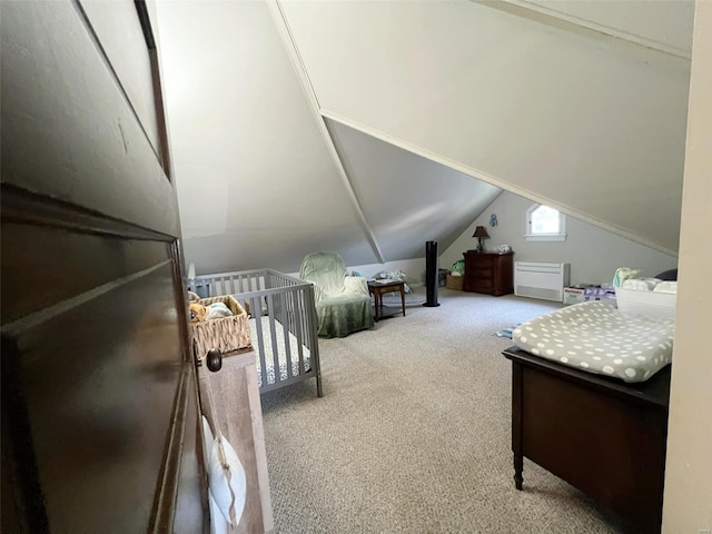 bedroom featuring a crib, lofted ceiling, and carpet floors