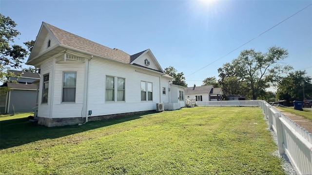 view of side of home with cooling unit and a lawn