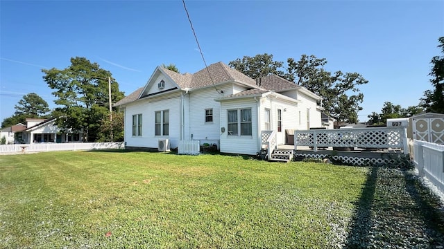 back of house with a yard, a storage unit, and a wooden deck