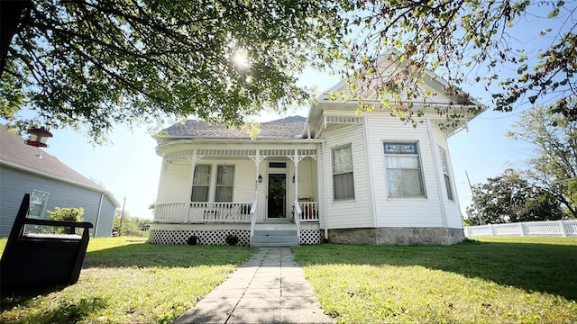 view of front of property featuring covered porch and a front lawn