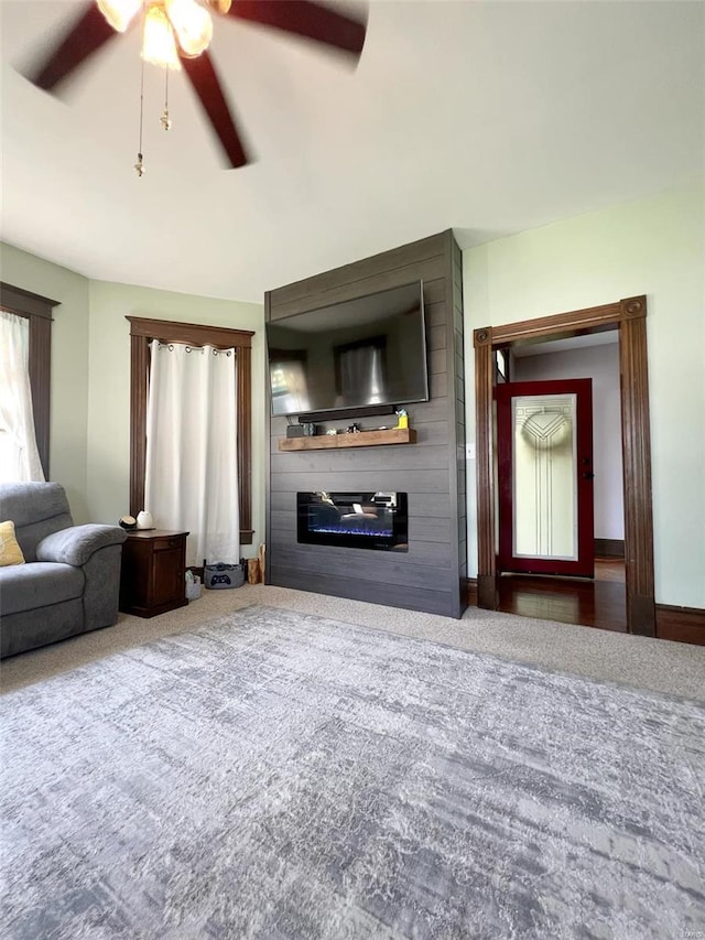 living room featuring ceiling fan and carpet