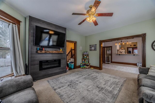 carpeted living room featuring ceiling fan and a fireplace