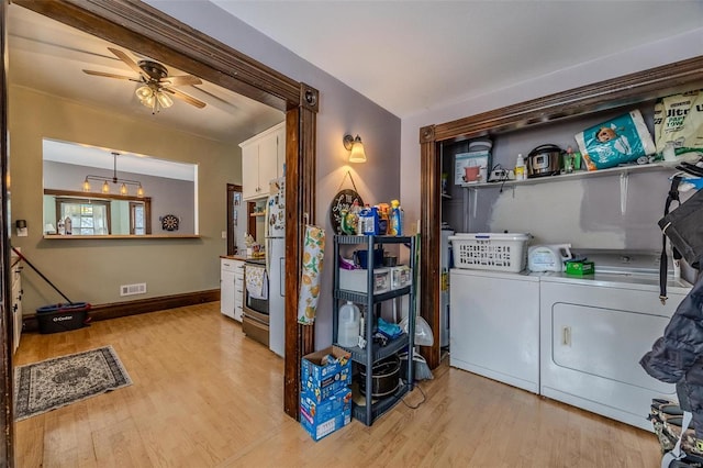 laundry room featuring ceiling fan, washing machine and clothes dryer, and light hardwood / wood-style floors