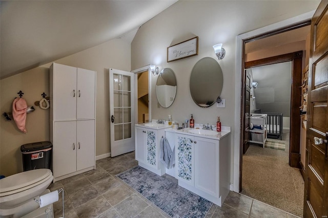 bathroom with lofted ceiling, toilet, and vanity