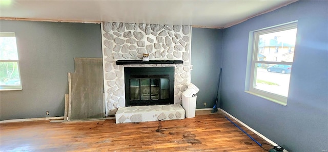 details with a stone fireplace, baseboards, and wood finished floors