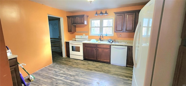 kitchen with white appliances, light countertops, a sink, and light wood finished floors