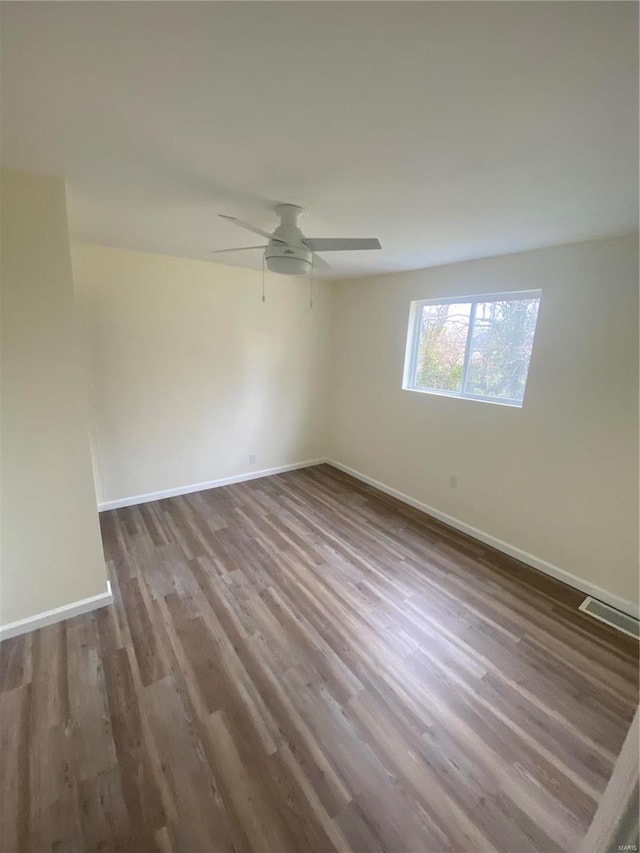 empty room featuring ceiling fan and dark hardwood / wood-style flooring