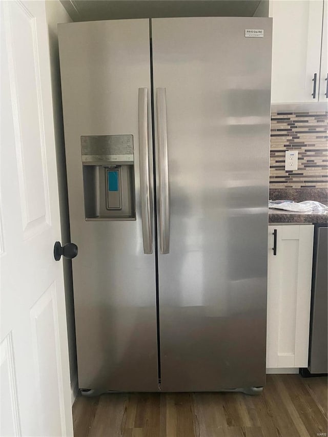 room details with stainless steel refrigerator with ice dispenser, dark hardwood / wood-style flooring, tasteful backsplash, and white cabinetry