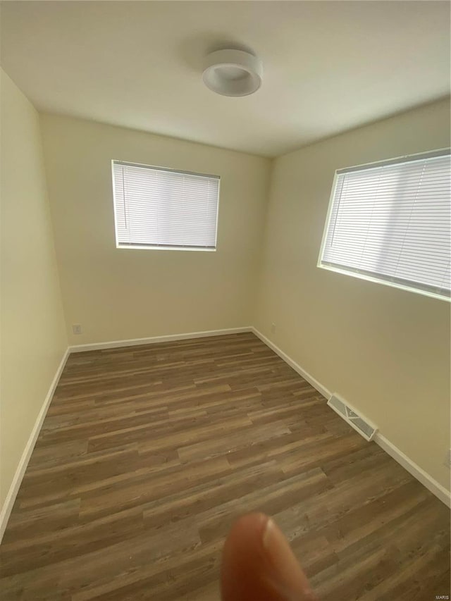 unfurnished room with dark hardwood / wood-style flooring