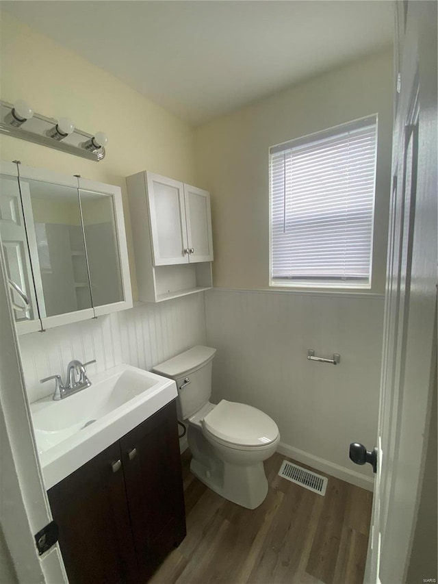 bathroom with hardwood / wood-style flooring, vanity, and toilet