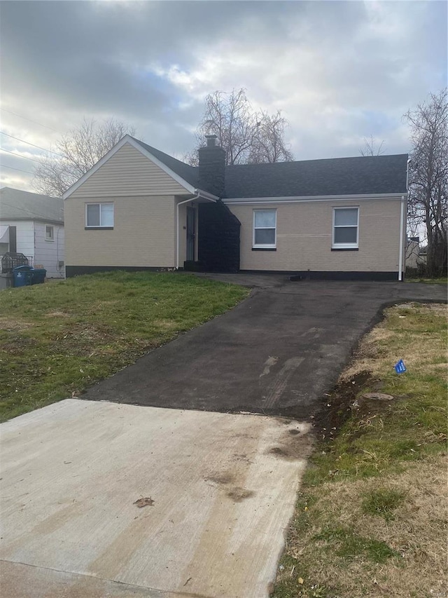 single story home featuring a front lawn