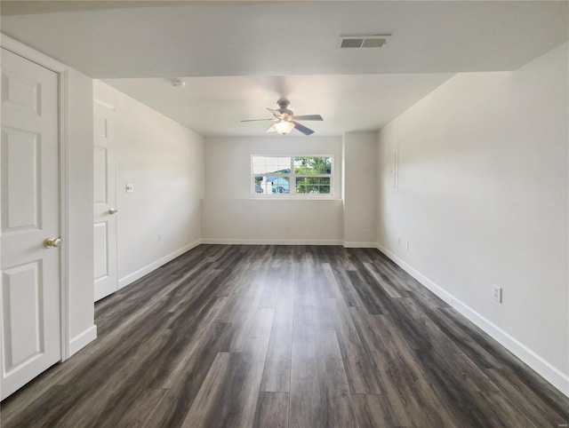 empty room with dark hardwood / wood-style flooring and ceiling fan