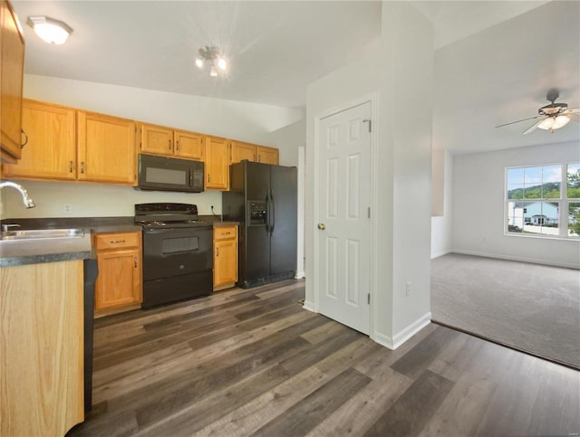 kitchen featuring black appliances, sink, vaulted ceiling, ceiling fan, and dark hardwood / wood-style floors