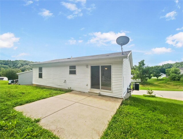 back of property with a lawn and a patio area