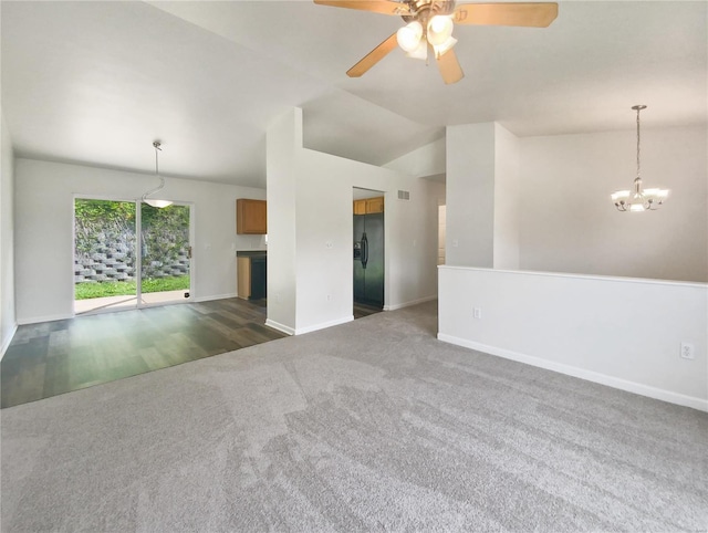 carpeted empty room with ceiling fan with notable chandelier and vaulted ceiling