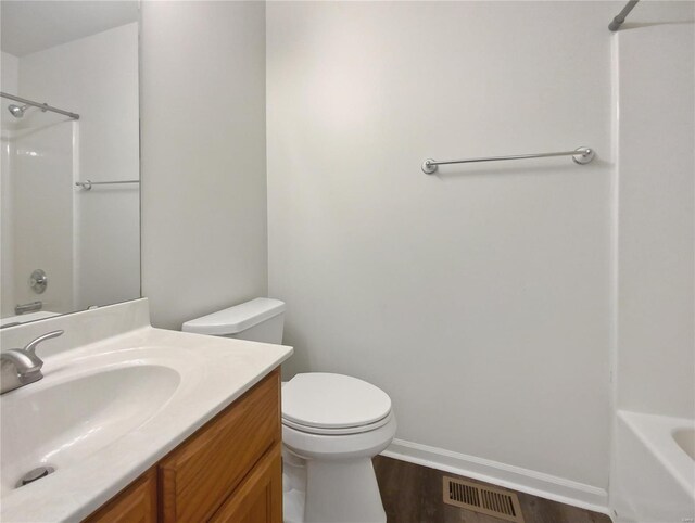 full bathroom with tub / shower combination, toilet, vanity, and wood-type flooring