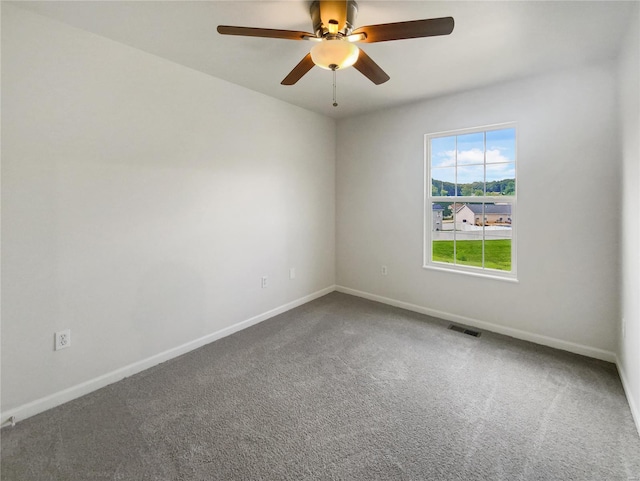 carpeted spare room featuring ceiling fan