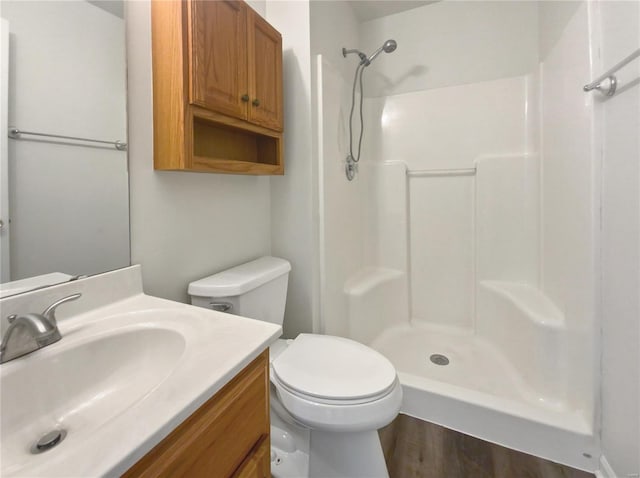 bathroom featuring hardwood / wood-style floors, vanity, toilet, and walk in shower