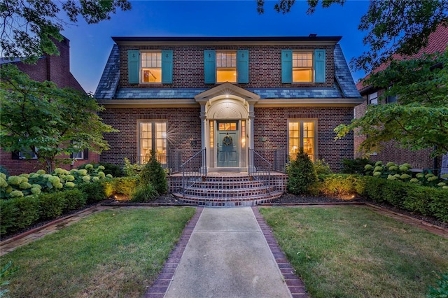 view of front of property featuring brick siding and a front lawn