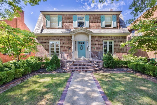 view of front facade featuring brick siding and a front lawn