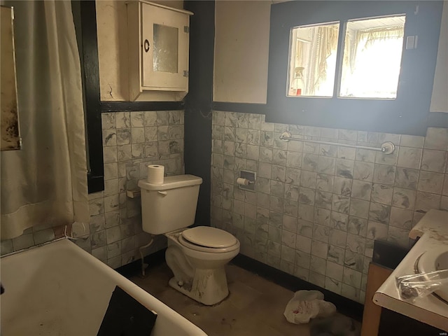 bathroom featuring vanity, tile walls, and toilet