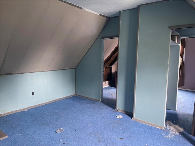 bonus room featuring vaulted ceiling and light carpet