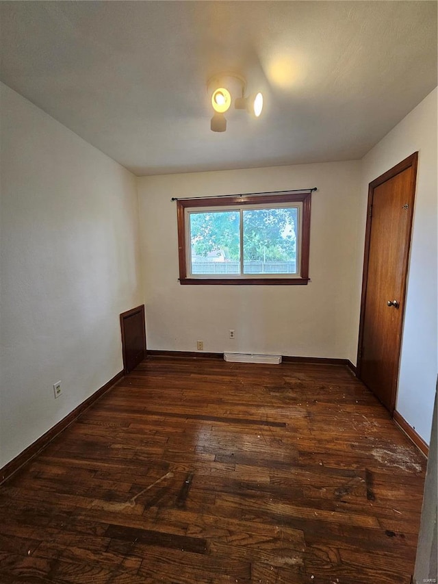 unfurnished bedroom with dark wood-style floors, visible vents, and baseboards