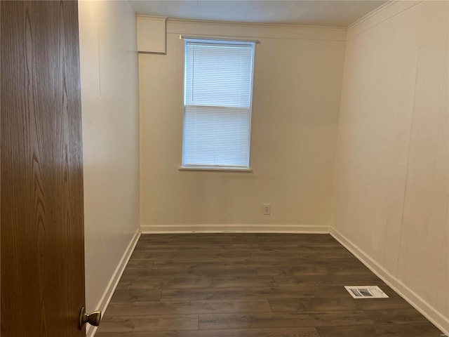 unfurnished room featuring ornamental molding and dark hardwood / wood-style flooring