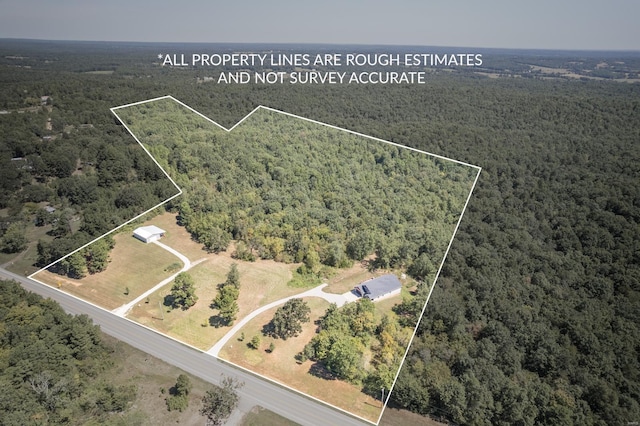 birds eye view of property with a wooded view