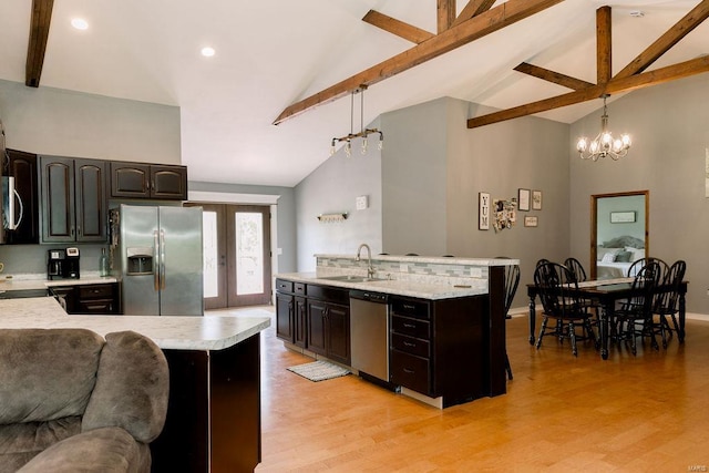 kitchen featuring appliances with stainless steel finishes, light hardwood / wood-style flooring, beamed ceiling, and hanging light fixtures