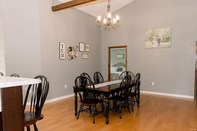 dining area featuring beam ceiling, high vaulted ceiling, light hardwood / wood-style floors, and a chandelier