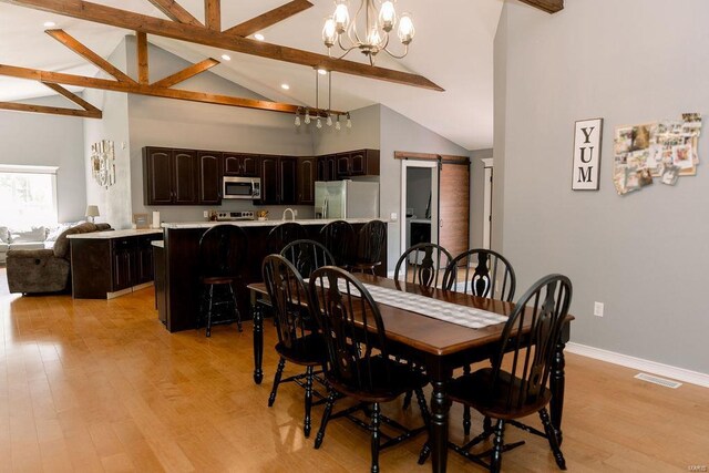 dining space with light hardwood / wood-style floors, beam ceiling, high vaulted ceiling, and a notable chandelier