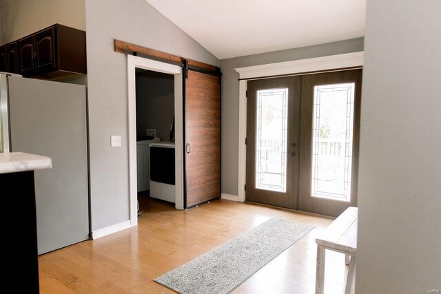 foyer with a wealth of natural light, light wood-type flooring, and french doors