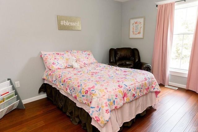 bedroom with baseboards and wood finished floors