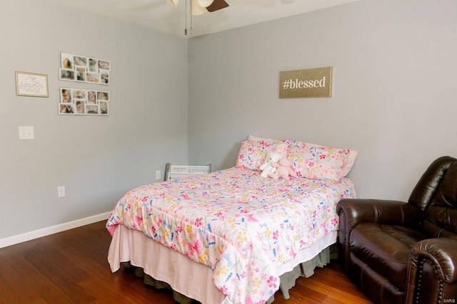 bedroom featuring a ceiling fan, baseboards, and wood finished floors