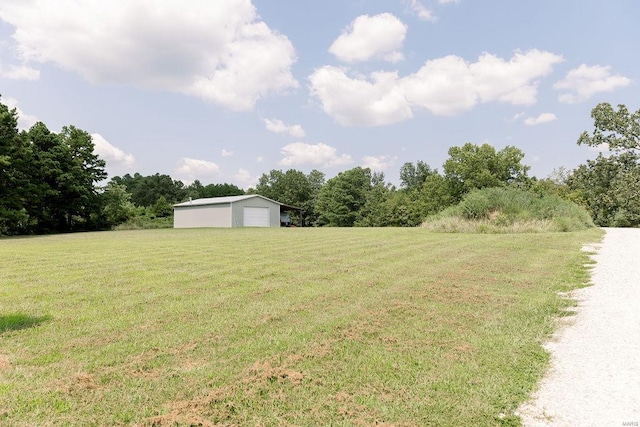 view of yard with a garage and an outbuilding