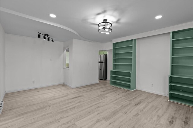 empty room featuring light wood-type flooring and rail lighting