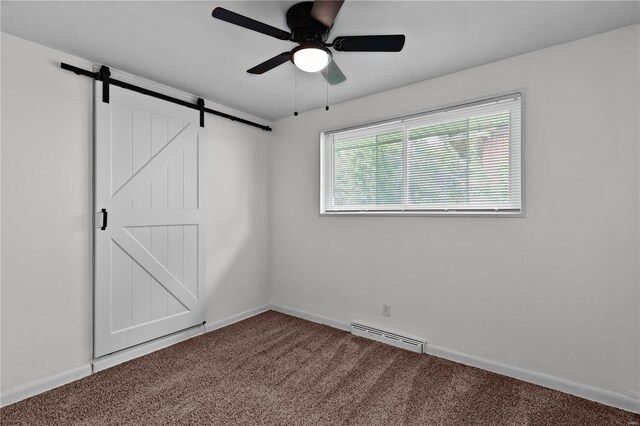 spare room featuring baseboard heating, ceiling fan, a barn door, and carpet floors