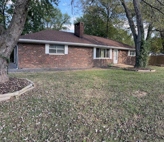 back of property featuring a lawn