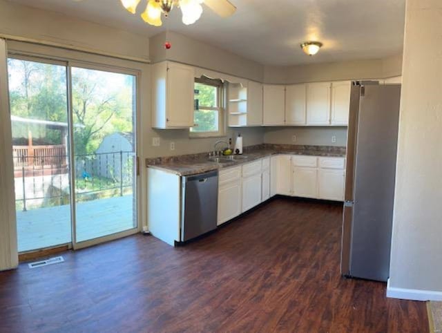 kitchen featuring white cabinets, ceiling fan, appliances with stainless steel finishes, dark hardwood / wood-style flooring, and sink