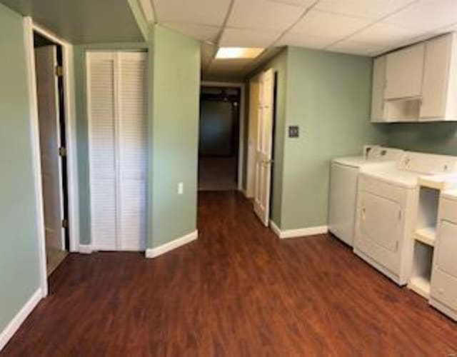 washroom with cabinets, washer and dryer, and dark wood-type flooring