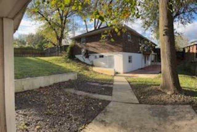 view of side of home with a patio area and a lawn