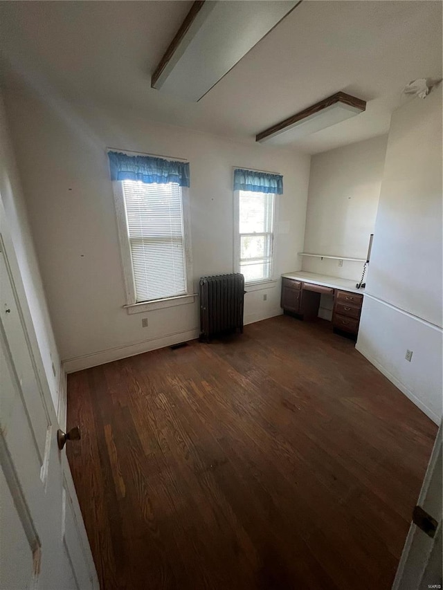 unfurnished bedroom with dark hardwood / wood-style floors and radiator