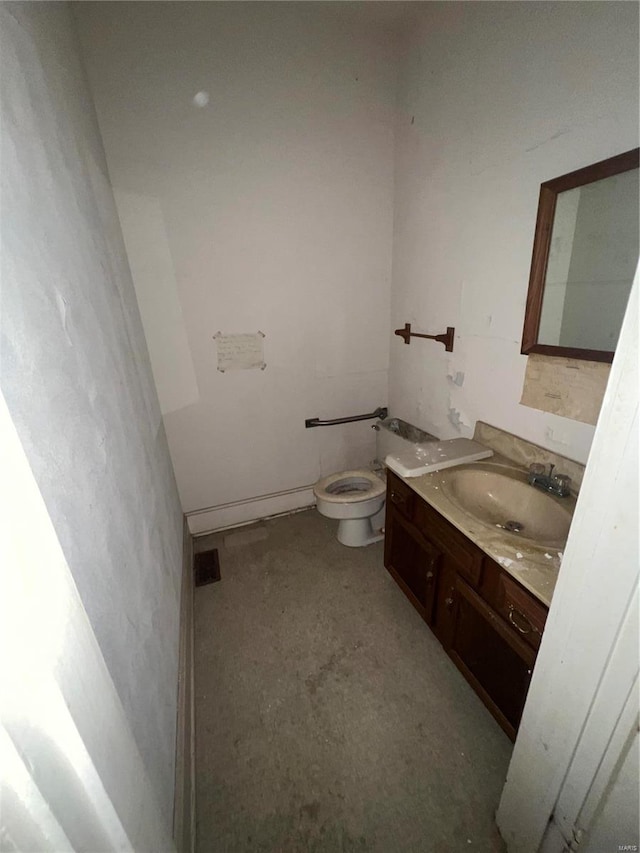 bathroom featuring vanity, toilet, and concrete floors