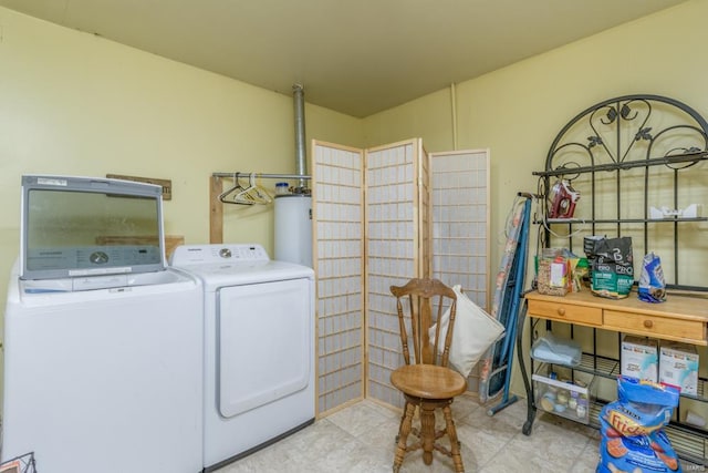 clothes washing area with washing machine and dryer, light tile patterned flooring, and gas water heater