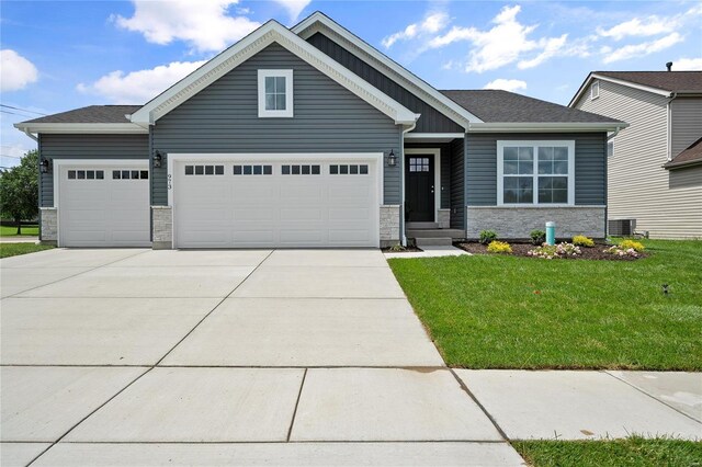 craftsman-style home featuring a front lawn, cooling unit, and a garage