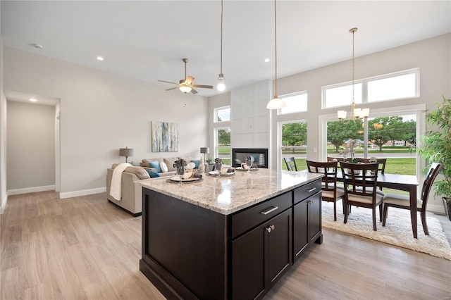 kitchen with a tiled fireplace, light hardwood / wood-style flooring, and a healthy amount of sunlight