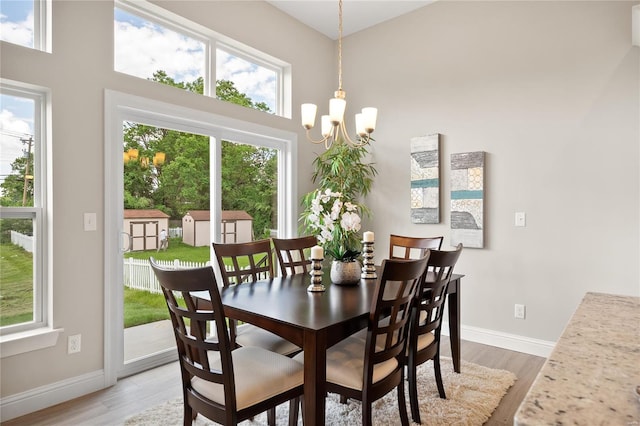 dining space with light hardwood / wood-style flooring and an inviting chandelier